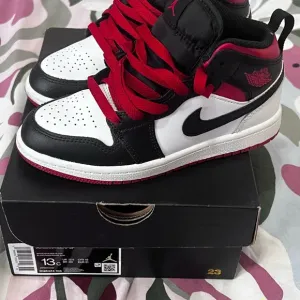Nike Black and Red Sneakers with Iconic Swoosh and High Ankle Design